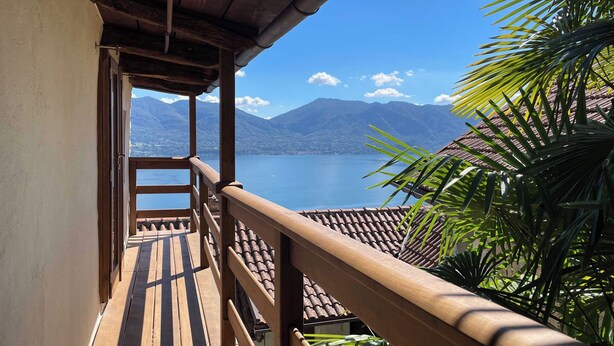 A wooden balcony with a view of a lake and mountains. - Casa del Prete (Cannero Riviera)