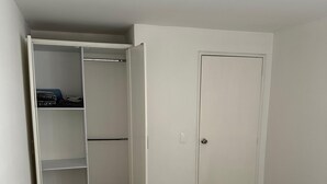 A bedroom with a bed, a wardrobe, and a door. - Apartamento loft cali (Cali)