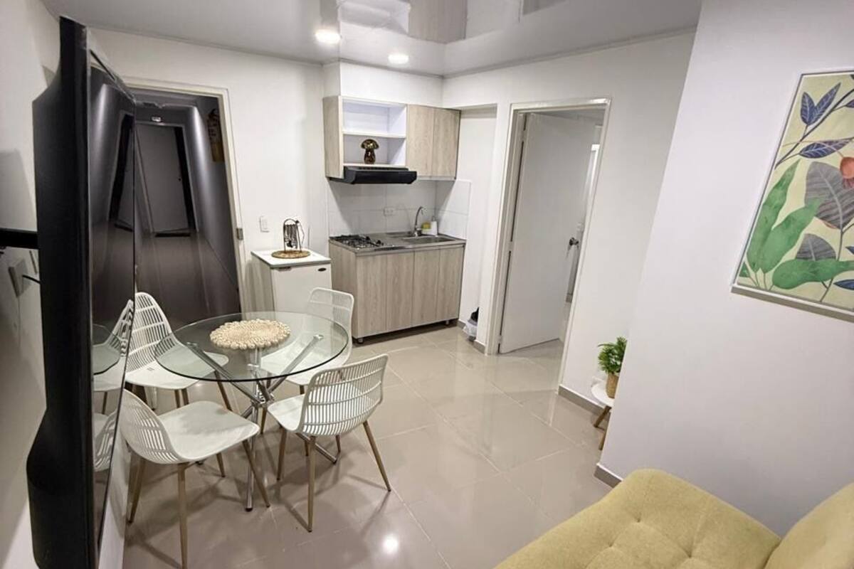 A compact living space with a dining area, kitchenette, and a sofa.