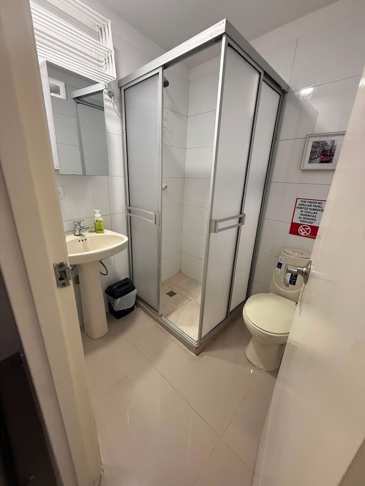 Une salle de bain avec une douche à parois de verre, un lavabo et des toilettes.