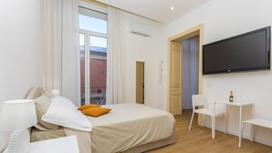 Una habitación de hotel moderna con una cama, televisión, escritorio y silla.