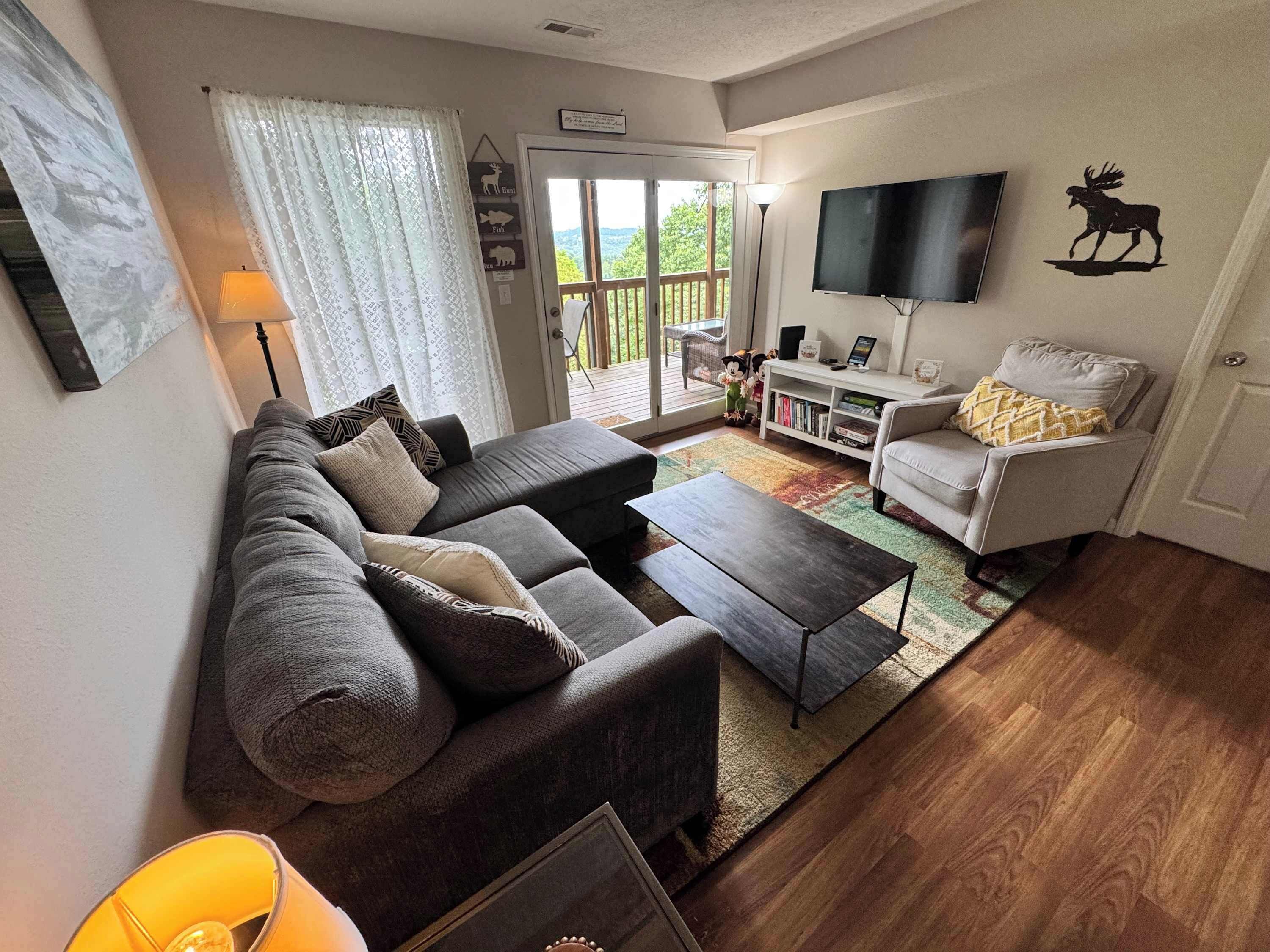 A living room with a sofa, coffee table, and a television.