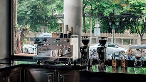 Eine moderne Bar mit einer Kaffeemaschine, Pendelleuchten und Blick auf die Straße.