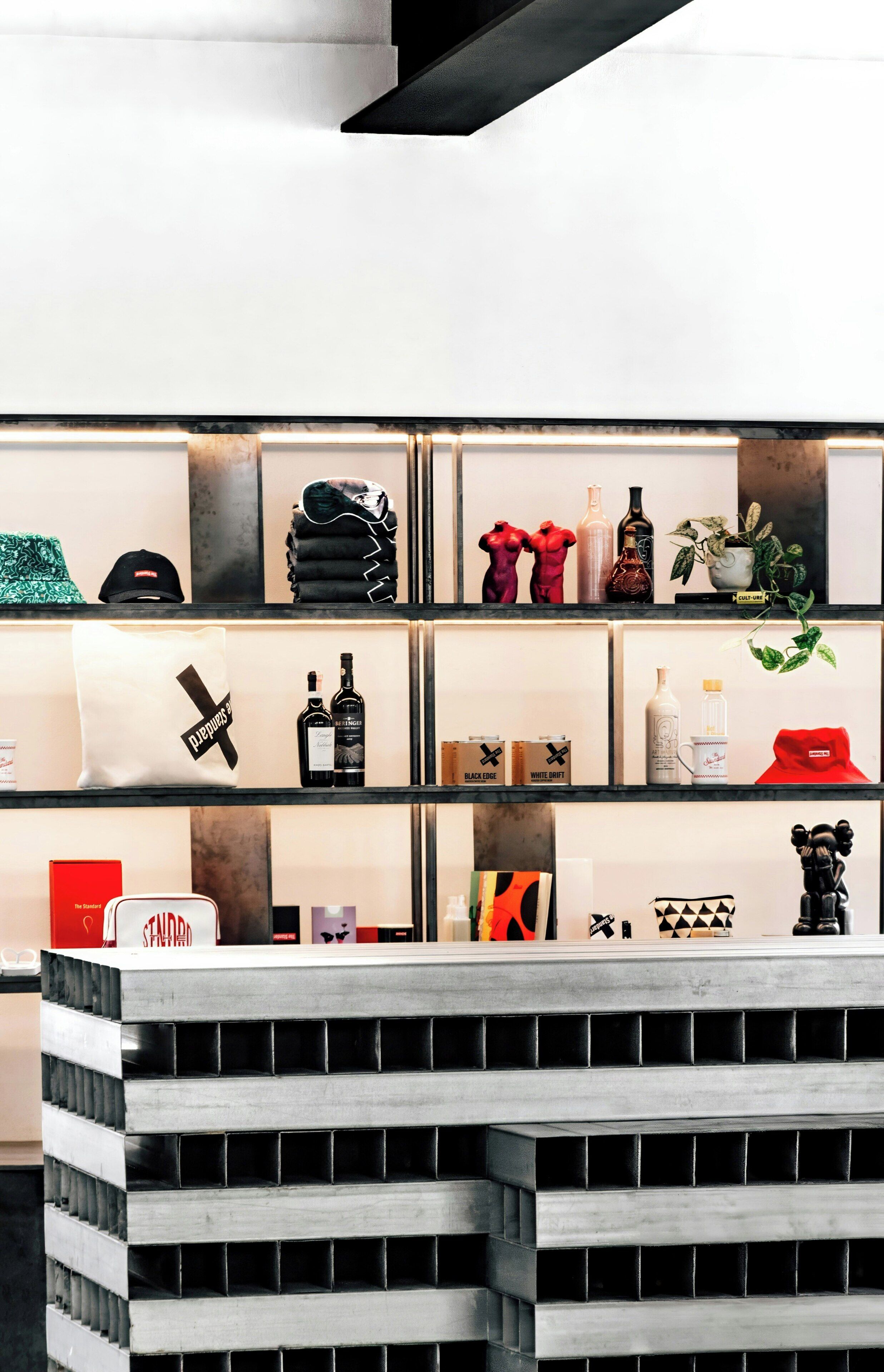 A modern interior with a central black and white striped counter, glass display shelves with various items, and a minimalist design.