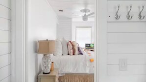 Une chambre à coucher avec un lit, une table de chevet avec une lampe et un luminaire fixé au mur.