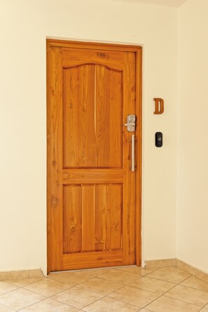 Una puerta de madera con un ojo de cerradura y un timbre.