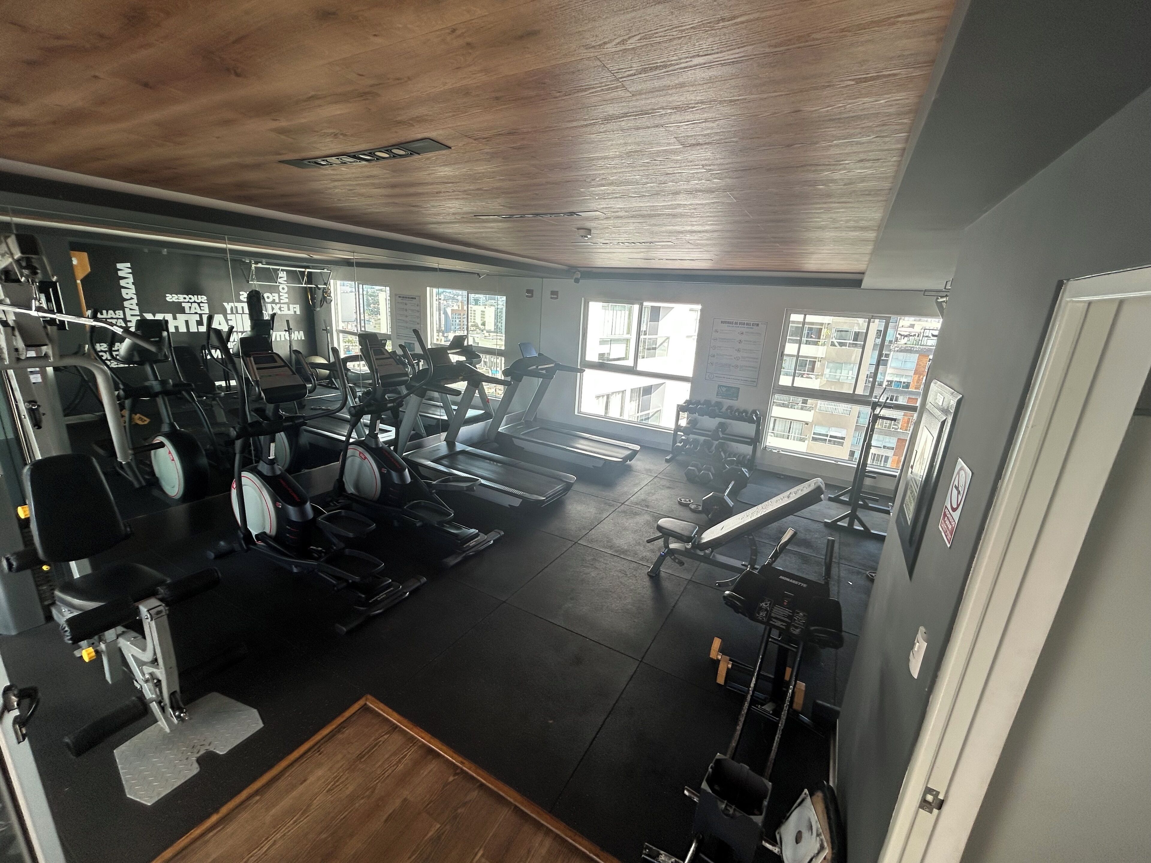 A gym with treadmills, weight machines, and free weights.