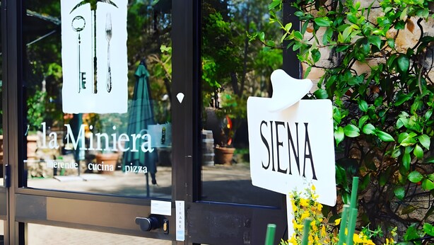 A storefront with a sign reading 'la Miniera' and another sign 'SIENA'.