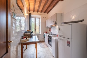 Une cuisine avec un plafond en bois, une fenêtre, un évier et un réfrigérateur.