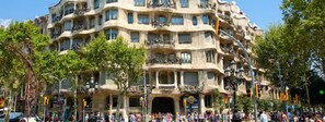 Um edifício de vários andares com varandas e uma multidão de pessoas na frente.