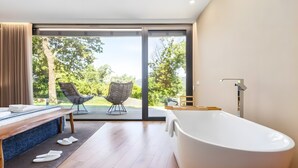 A modern bathroom with a freestanding bathtub, a wooden bench, and a glass-enclosed shower area. - Chalet 'Casas De Bouro 3 Do Alecrim' with Private Sauna and Jacuzzi (Terras de Bouro)