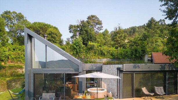 A modern house with a patio, outdoor seating, and a hot tub. - Chalet 'Casas De Bouro 3 Do Alecrim' with Private Sauna and Jacuzzi (Terras de Bouro)