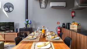 A modern dining area with a wooden table, black chairs, and a central light fixture. - Chalet 'Casas De Bouro 3 Do Alecrim' with Private Sauna and Jacuzzi (Terras de Bouro)
