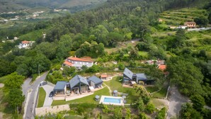 A residential area with houses, a swimming pool, and a road. - Chalet 'Casas De Bouro 3 Do Alecrim' with Private Sauna and Jacuzzi (Terras de Bouro)
