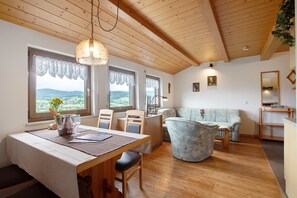 Comedor con mesa, sillas y vista al exterior.