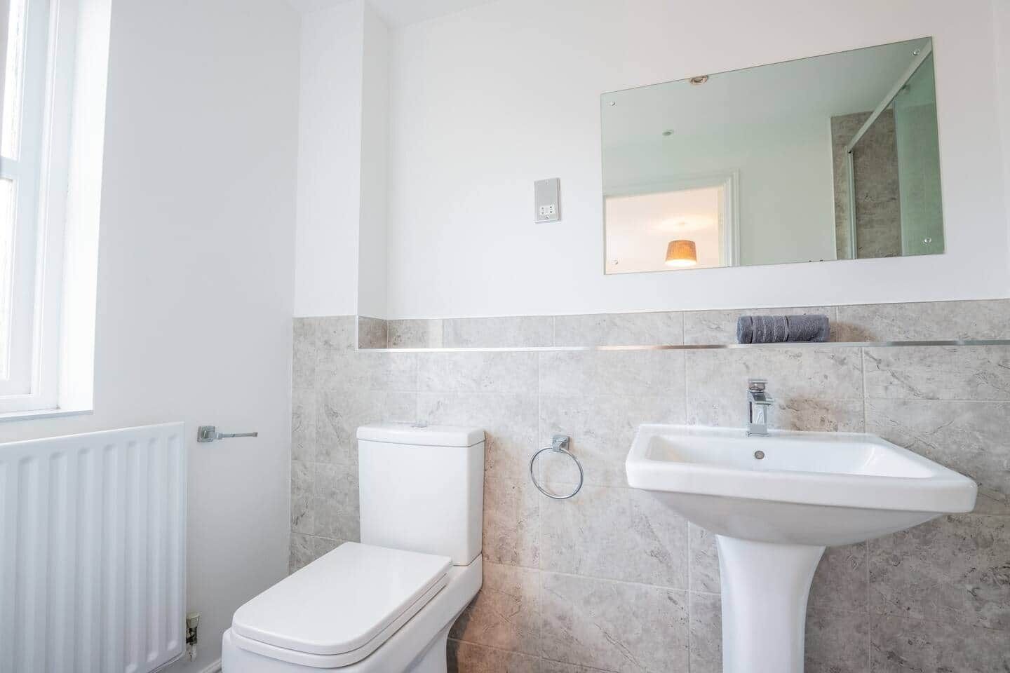 Ein Badezimmer mit Toilette, Waschbecken und Spiegel.