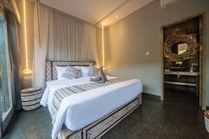 Une chambre d’hôtel avec un grand lit, des lampes de chevet, une coiffeuse avec un miroir et un plancher foncé.