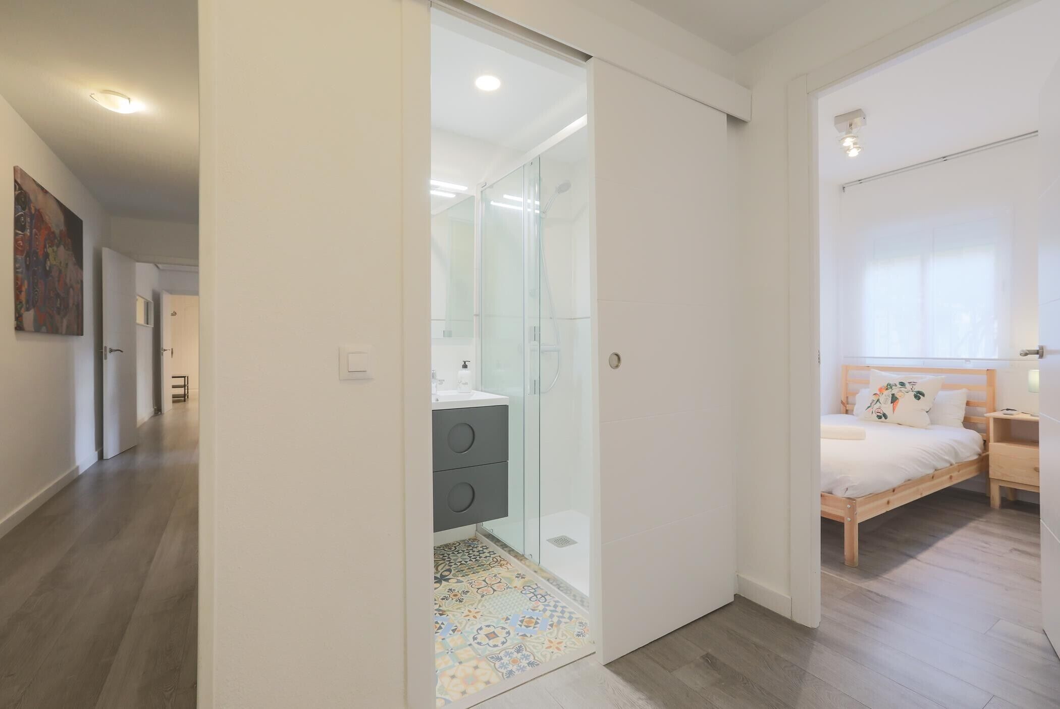 A bedroom with a bed, bedside table, and a window.