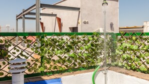 Een dak met een fontein, een metalen constructie en een groene hek.