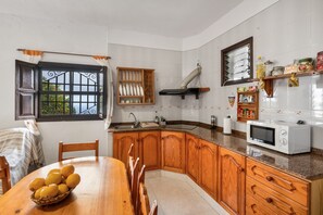 Una cucina con mobili in legno, un forno a microonde e un lavello.