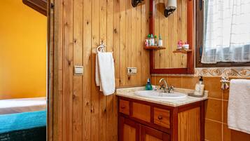 A wooden bathroom with a sink, mirror, and towel rack.