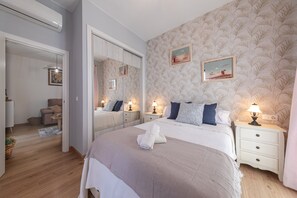 Quarto com cama grande, mesas de cabeceira, espelho e guarda-roupa.