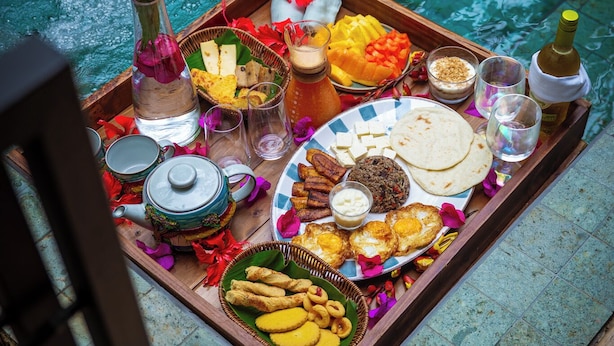 A tray of food and drinks by a poolside.