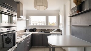 Eine moderne Küche mit eingebauten Geräten, einem großen Fenster und einem minimalistischen Design.
