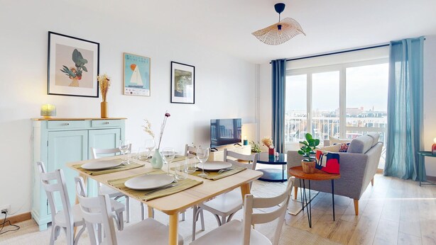 Ein modernes Wohnzimmer mit Essbereich, großen Fenstern und Blick auf die Stadt.