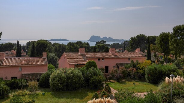 Quartiere residenziale con case, un giardino e vista mare.