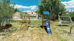 A playground with a slide, climbing structure, and swings. - Holiday Home Marin AS (Drnis)