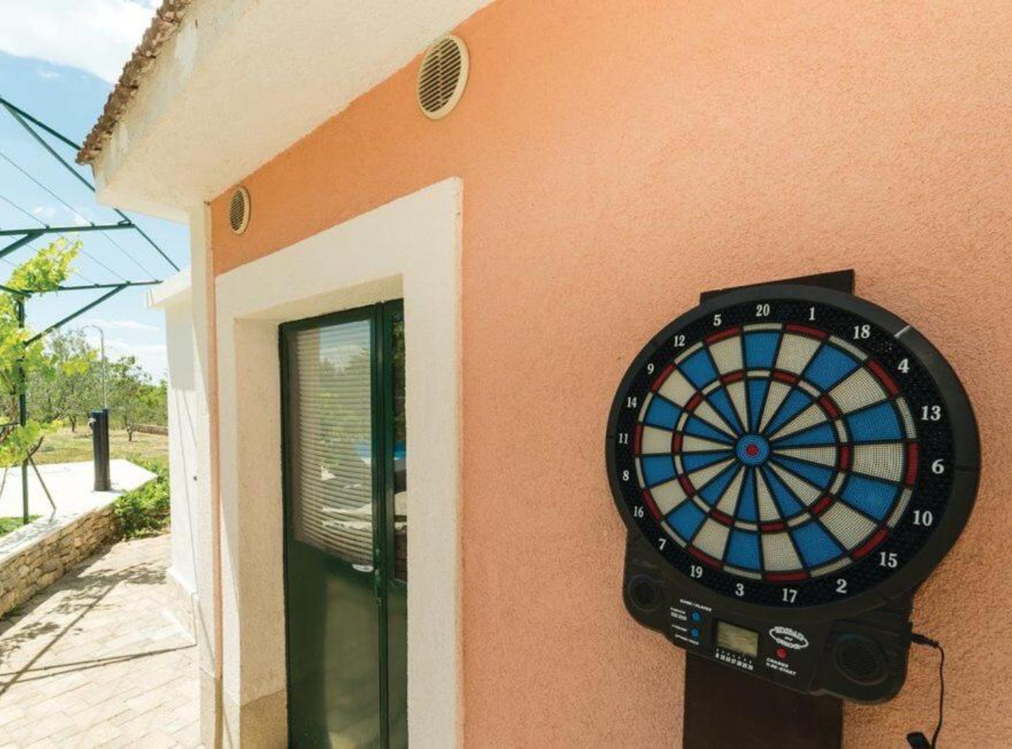 A dartboard mounted on a wall next to a door with a window.