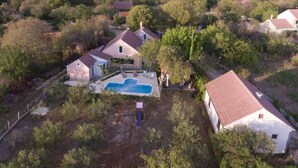A residential area with houses, a swimming pool, and surrounding greenery. - Holiday Home Marin AS (Drnis)
