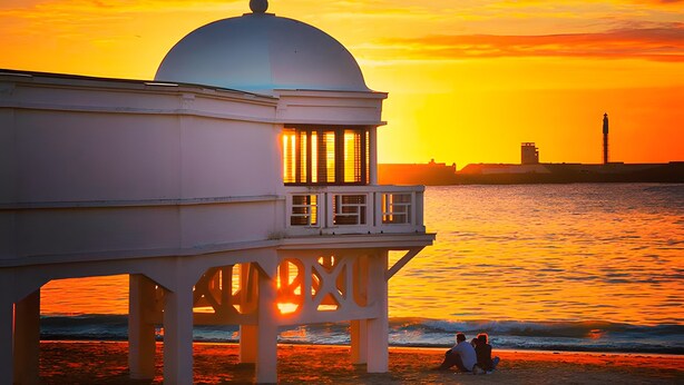 A seaside building with a dome, a balcony, and a view of the ocean at sunset. - Apartment 'La Bella Escondida' with Wi-Fi and Air Conditioning (Cadiz)