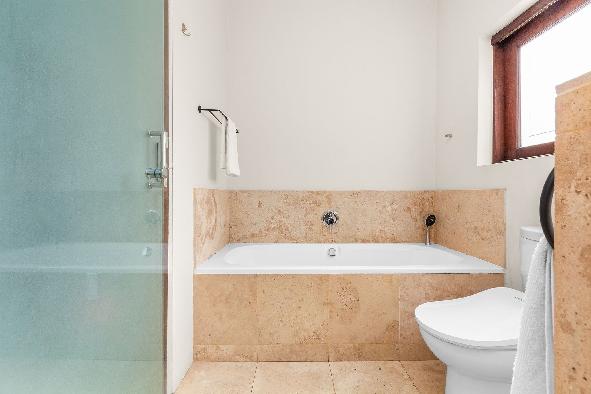 Ein modernes Badezimmer mit einer Glasdusche, einer freistehenden Badewanne und einem WC.