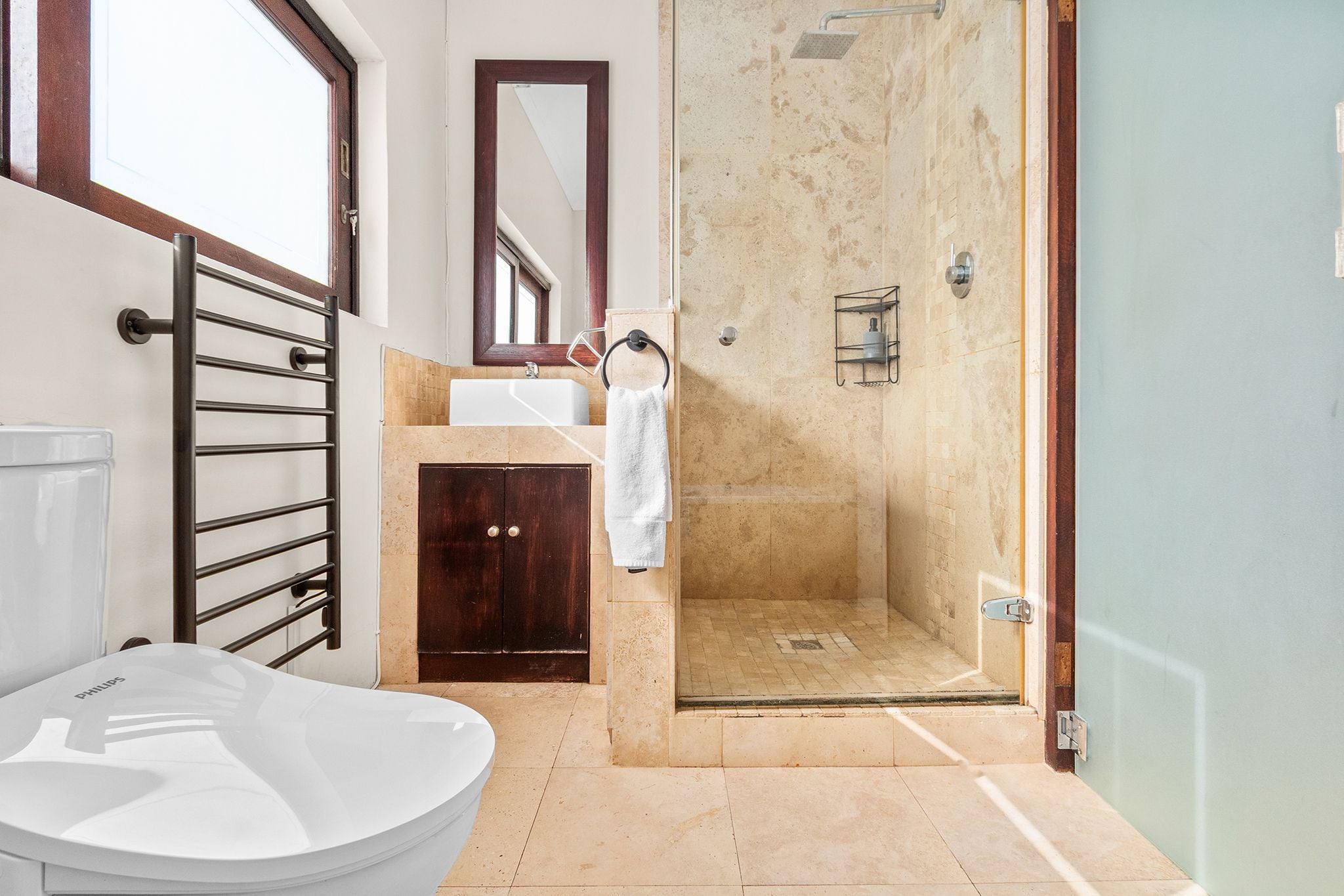 Une salle de bain moderne avec une baignoire sur pieds, une douche à parois de verre et un meuble-lavabo en bois.