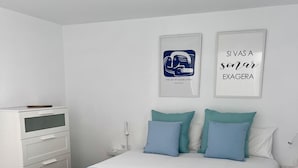 A bedroom with a bed, a bedside table, a nightstand, a dresser, and two wall art pieces. - Tartaga Penthouse (Adeje)