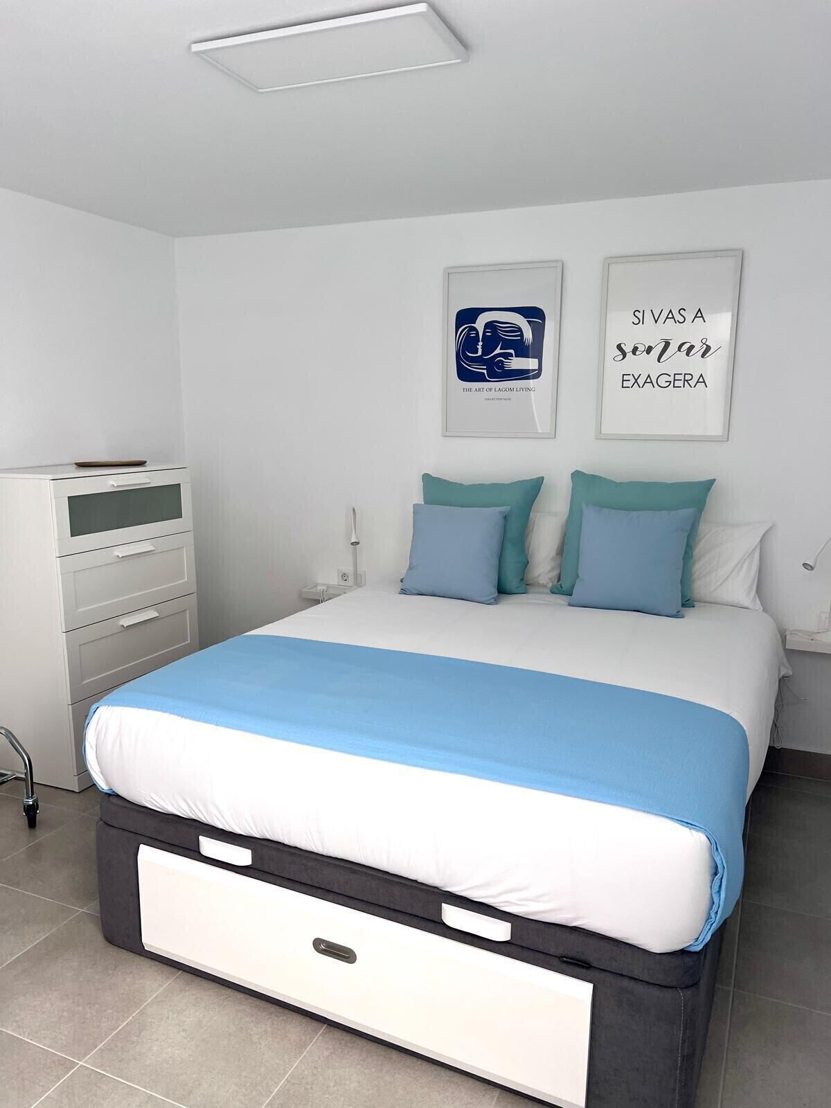 Une chambre à coucher comprenant un lit, une table de chevet, une commode, un bureau et une chaise.