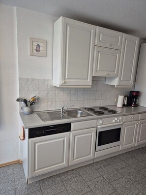 Réfrigérateur, un four, surface de cuisson, lave-vaisselle