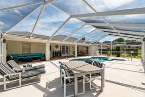 A covered outdoor area with a pool, lounge chairs, a table, and a sofa. - Villa Bettina: 2 bedroom / 2 bathroom with pool (Inverness)