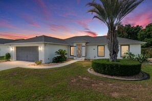 A single-story house with a garage, a front door, and a well-maintained lawn. - Villa Bettina: 2 bedroom / 2 bathroom with pool (Inverness)