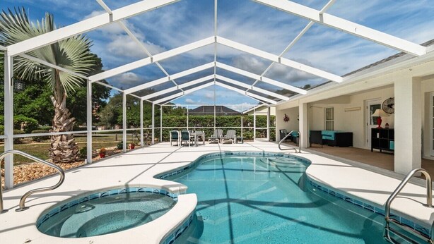 Una piscina cubierta al aire libre con sillas de descanso y un área de terraza.