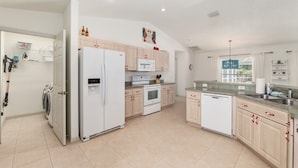 Una cocina moderna con horno empotrado, microondas y refrigerador.