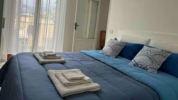 A bedroom with a bed, pillows, and folded towels. - Saraceno Holiday Home Piazza Indipendenza Palermo (Palermo)