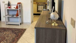 A modern living room with a wooden coffee table, a white shelving unit, and a patterned rug. - Saraceno Holiday Home Piazza Indipendenza Palermo (Palermo)