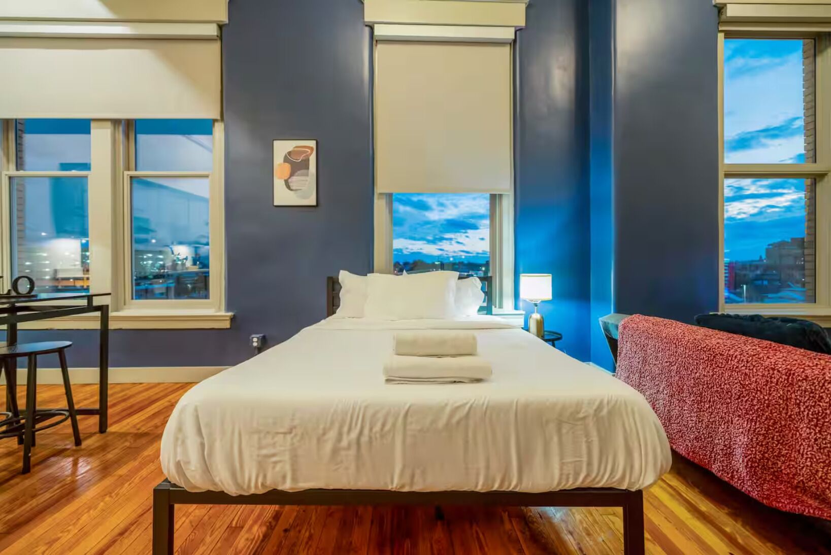 Une chambre d’hôtel avec un grand lit, un bureau et une vue sur la ville.