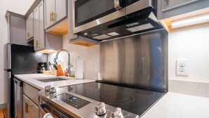 Uma cozinha moderna com eletrodomésticos de aço inoxidável, forno embutido e micro-ondas.