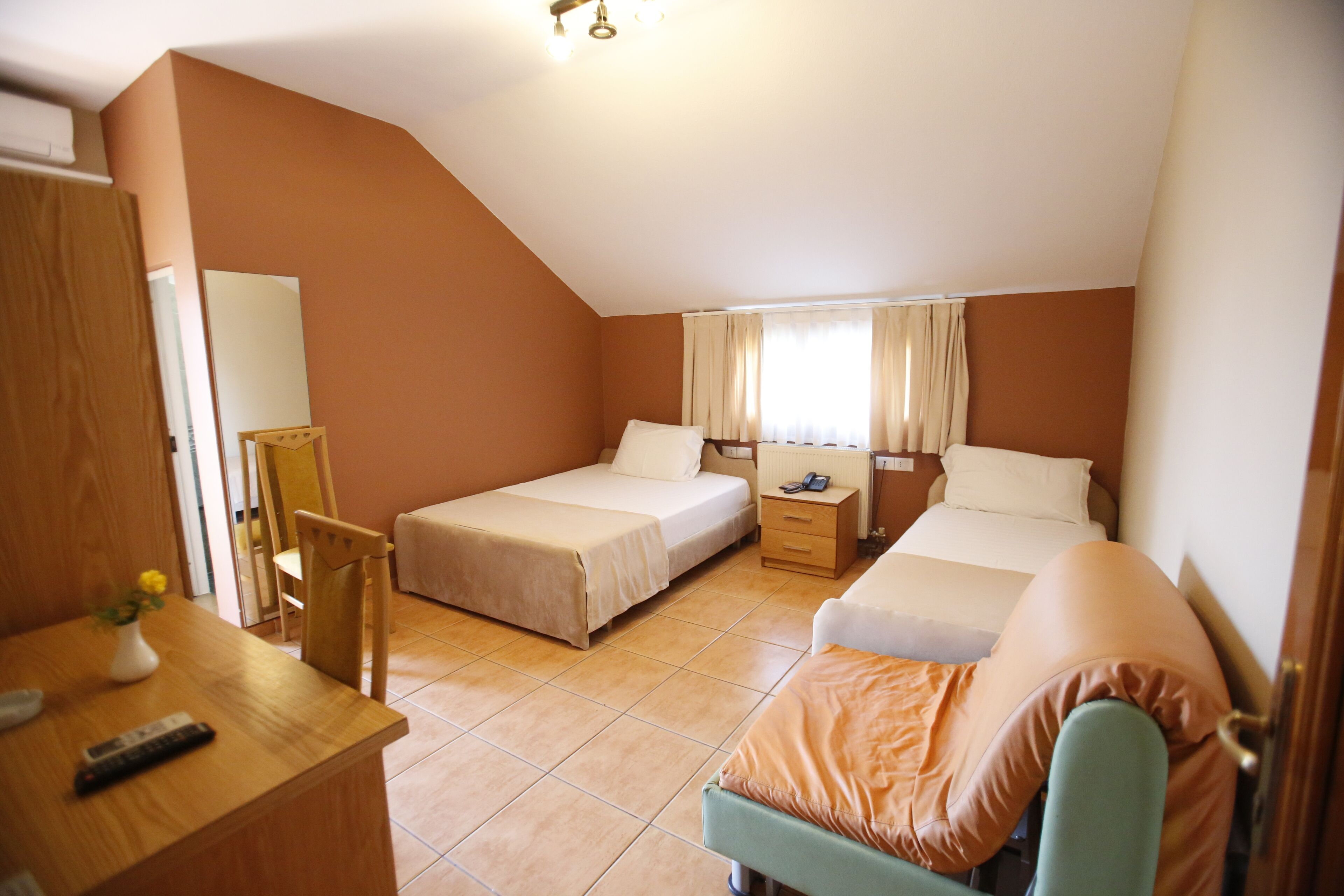 Ein Schlafzimmer mit zwei Betten, einem Schreibtisch und einem Stuhl.