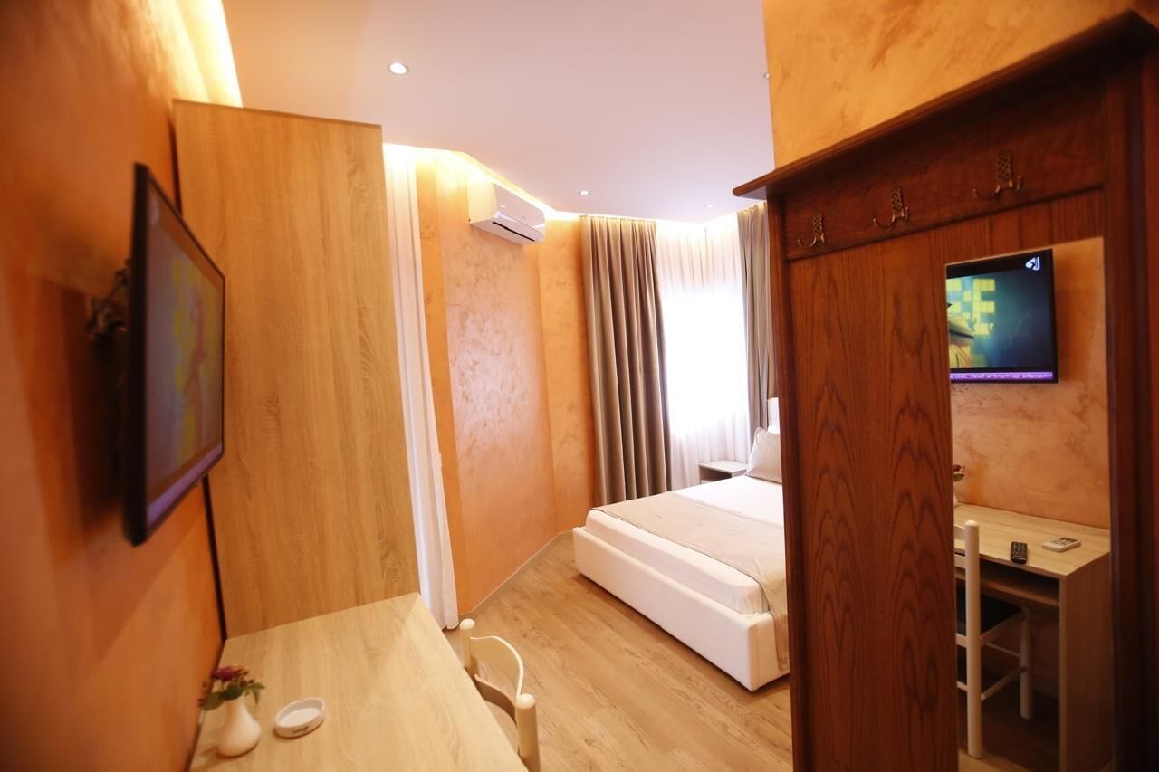 Une chambre d’hôtel équipée d’un lit, d’un bureau, d’une télévision et d’un appareil de climatisation.