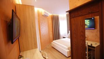 Une chambre d’hôtel équipée d’un lit, d’un bureau, d’une télévision et d’un appareil de climatisation.